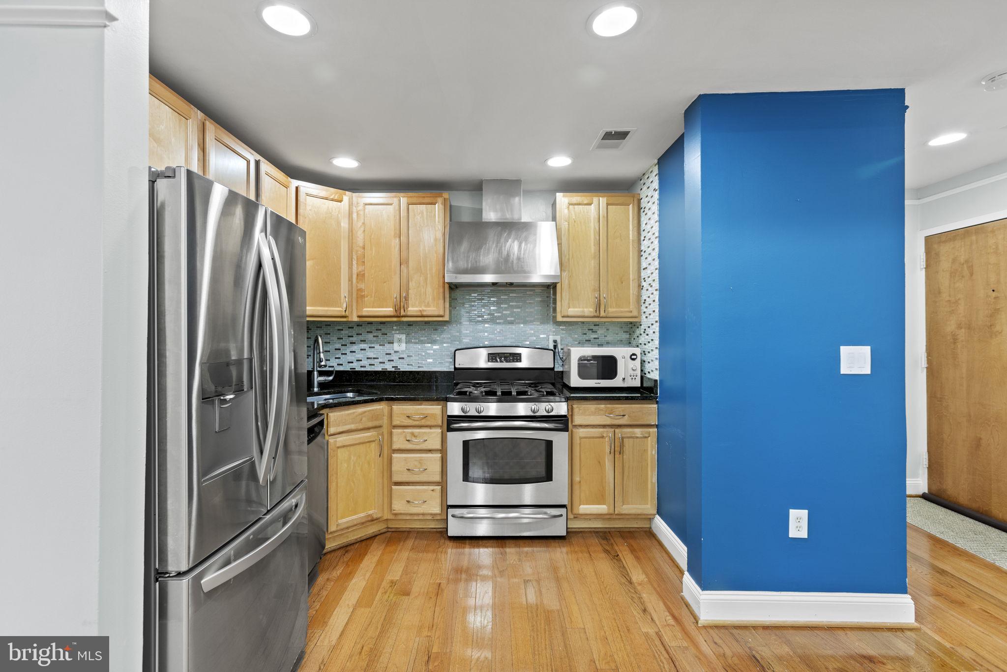 1437 Spring Road Northwest, Unit 21 Washington, DC 20010 - Photo 6 of 25 a kitchen with stainless steel appliances granite countertop a stove a refrigerator and a sink