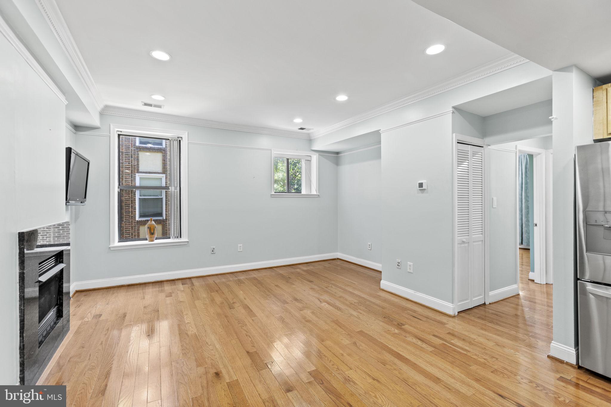 1437 Spring Road Northwest, Unit 21 Washington, DC 20010 - Photo 9 of 25 a view of an empty room with wooden floor and a window