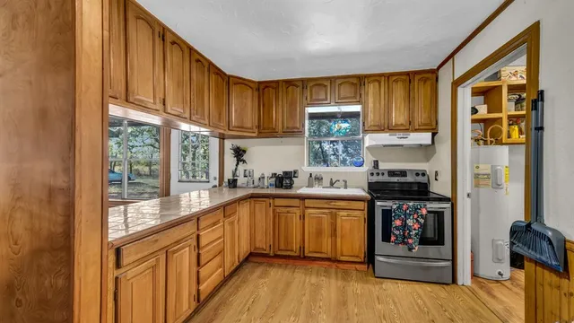 a kitchen with stainless steel appliances granite countertop a stove a sink and a refrigerator