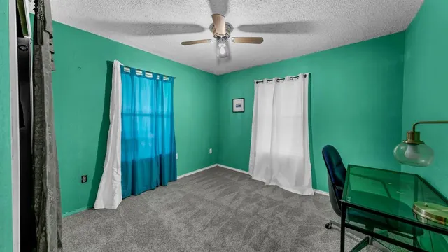 a view of a livingroom with furniture and a ceiling fan