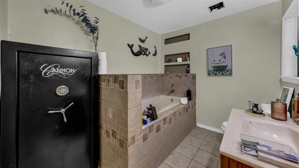 3200 Fairview Road Millsap, TX 76066 - Photo 23 of 33 a bathroom with a tub sink and mirror