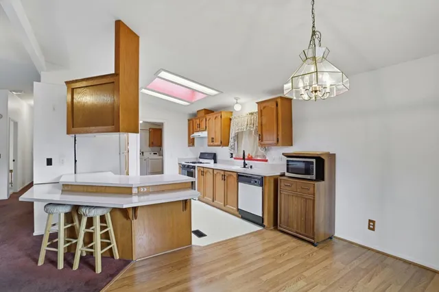 a kitchen with stainless steel appliances granite countertop a stove and a wooden floor