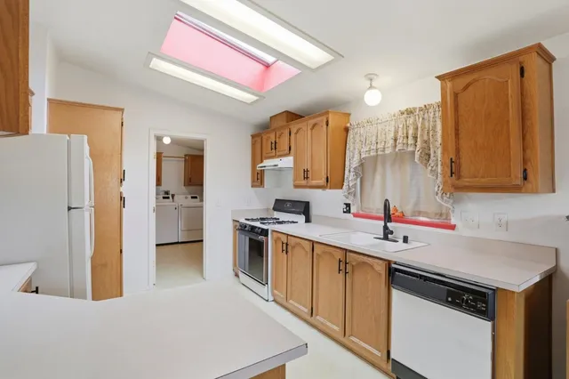 a kitchen with stainless steel appliances granite countertop a stove a sink and a refrigerator