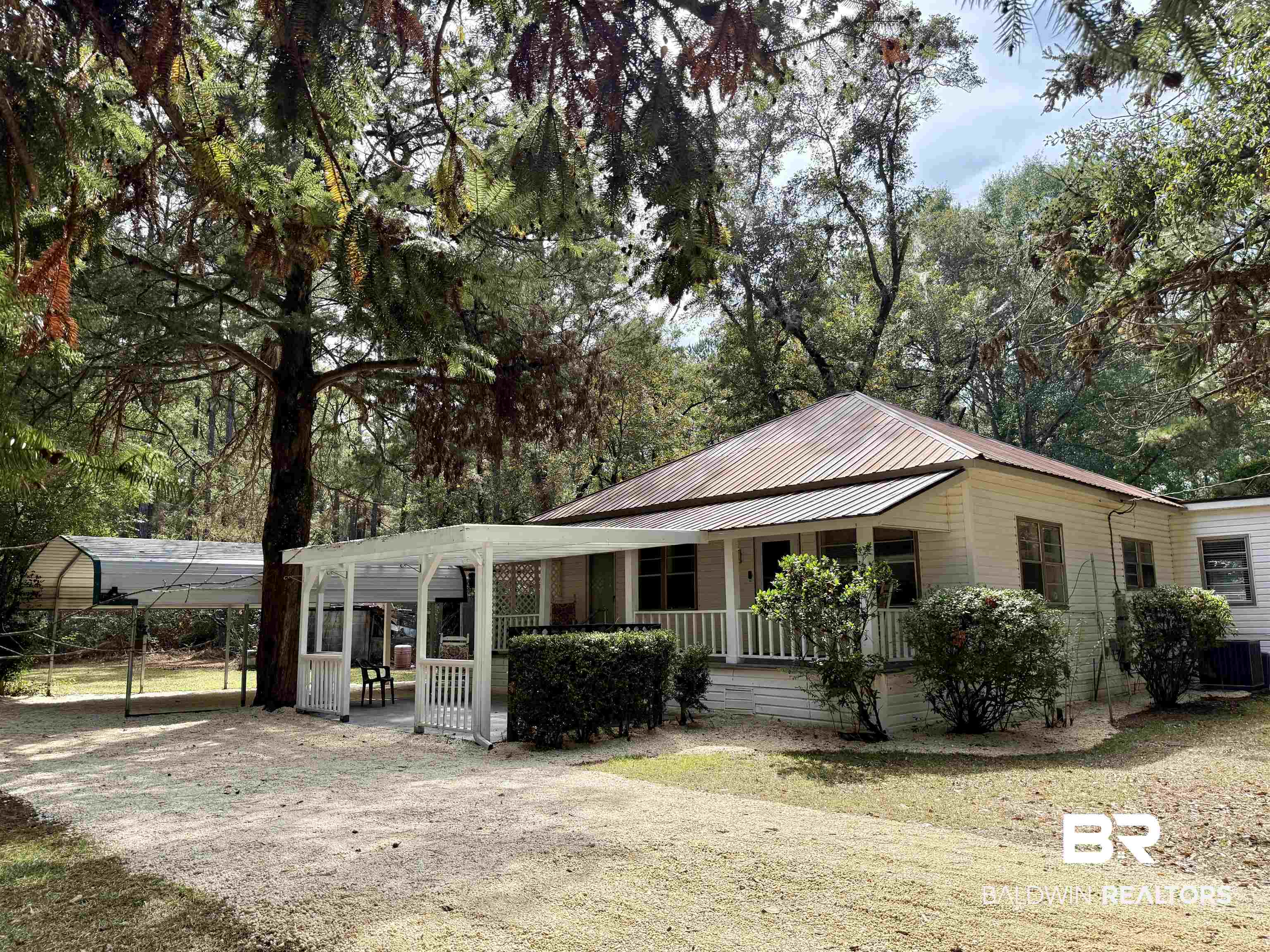 826 West Side Road Castleberry, AL 36432 - Photo 1 of 34 View of front of house with a metal roof, covered porch, and a front yard