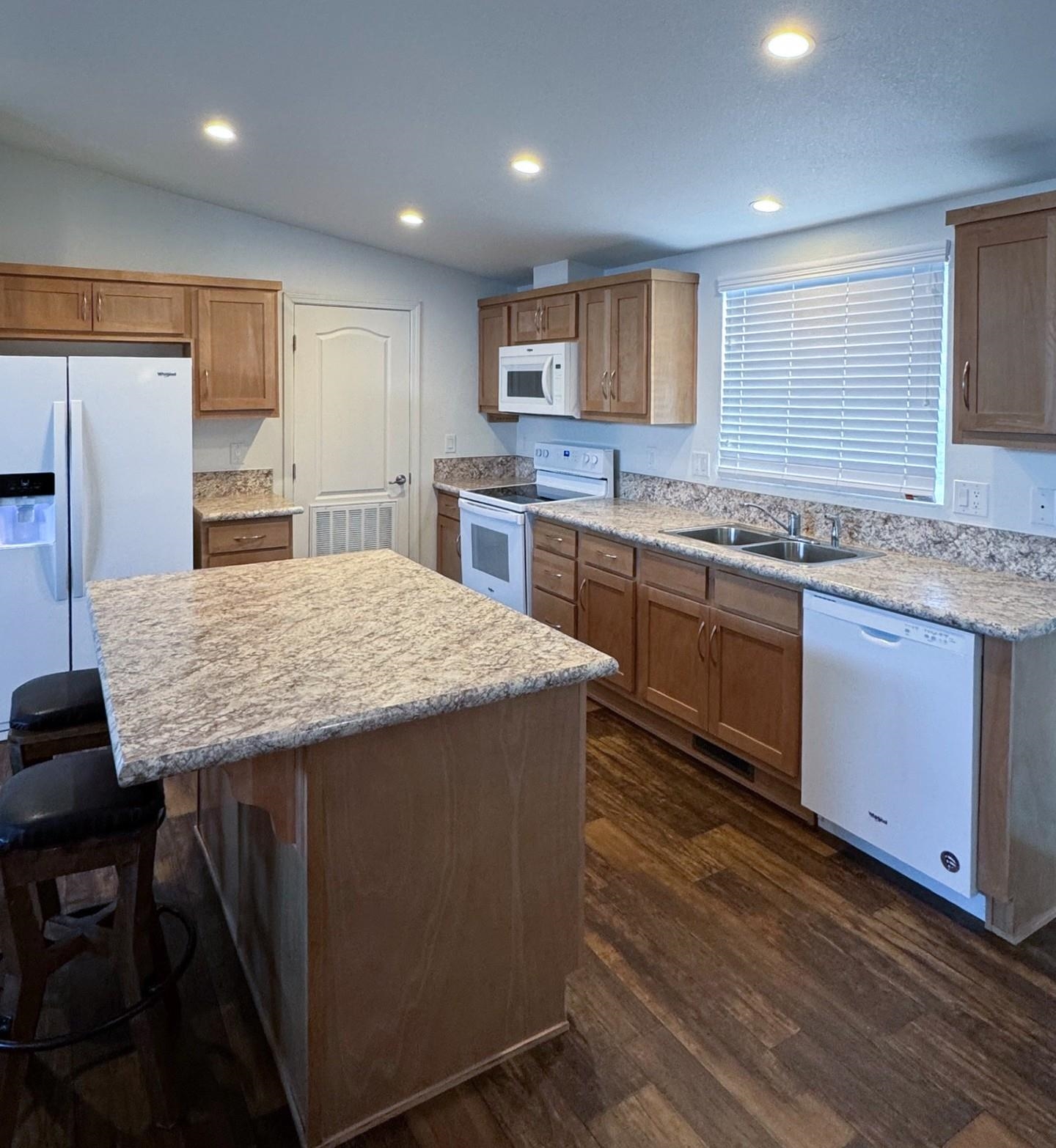 139 Tuolumne Road Bishop, CA 93514 - Photo 3 of 18 a kitchen with granite countertop kitchen island a sink stove and refrigerator