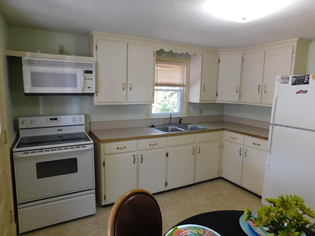 66 Notre Dame Street Springfield, MA 01104 - Photo 8 of 28 a kitchen with granite countertop white cabinets and white appliances