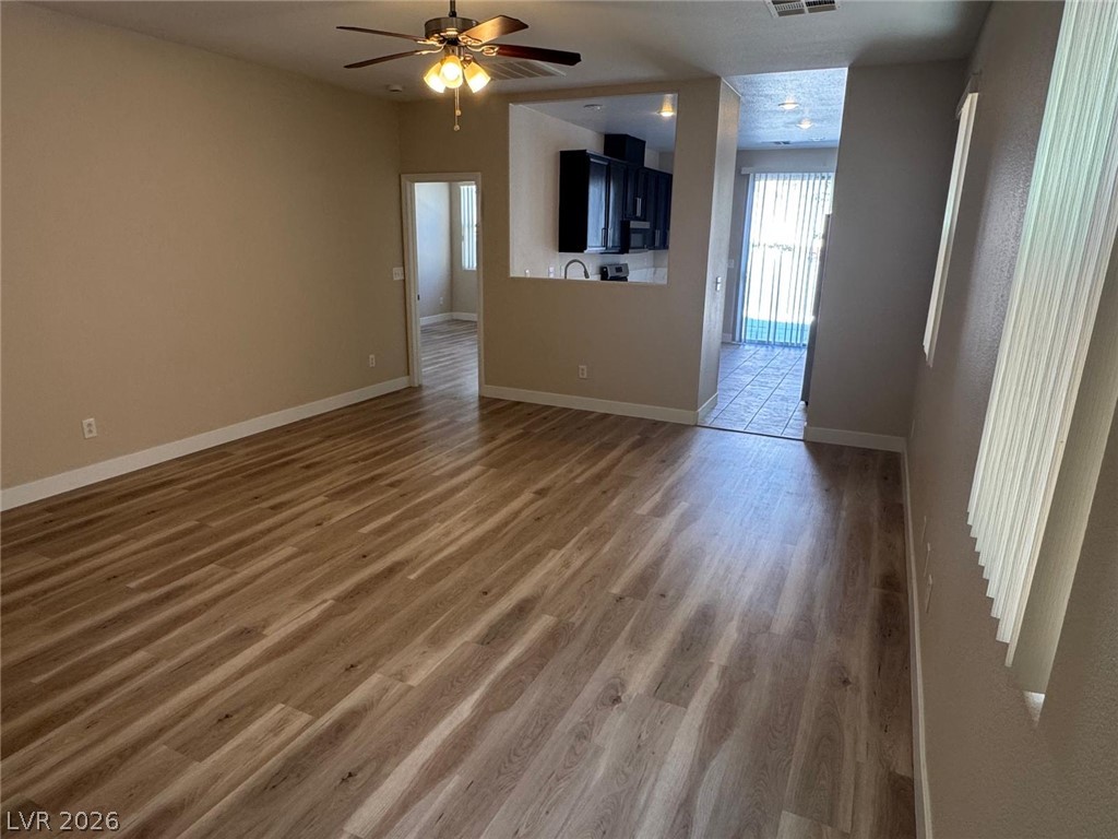 3962 Coyote Ridge Court Las Vegas, NV 89129 - Photo 11 of 35 A warm and inviting living space with durable plank flooring, illuminated by natural light and overhead fixtures.