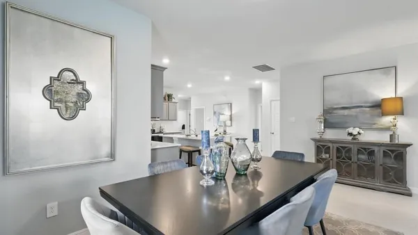 a kitchen with kitchen island a dining table and chairs