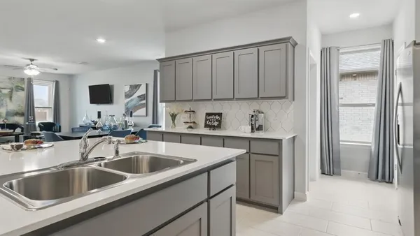 a kitchen with stainless steel appliances a stove a sink a microwave a refrigerator and cabinets