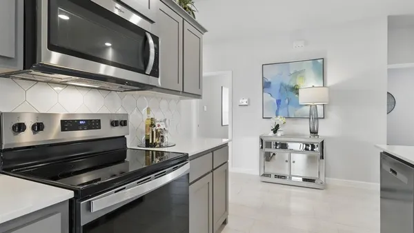 a kitchen with stainless steel appliances kitchen island a table chairs sink and cabinets