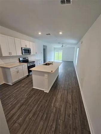 a view of kitchen with sink microwave and refrigerator