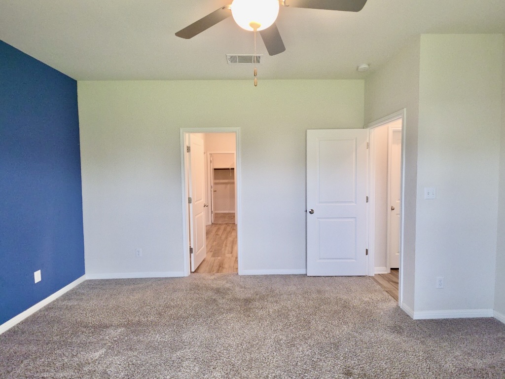 110 Grapefruit Road Hutto, TX 78634 - Photo 11 of 28 Bedroom with a ceiling fan, two windows, and textured carpet flooring