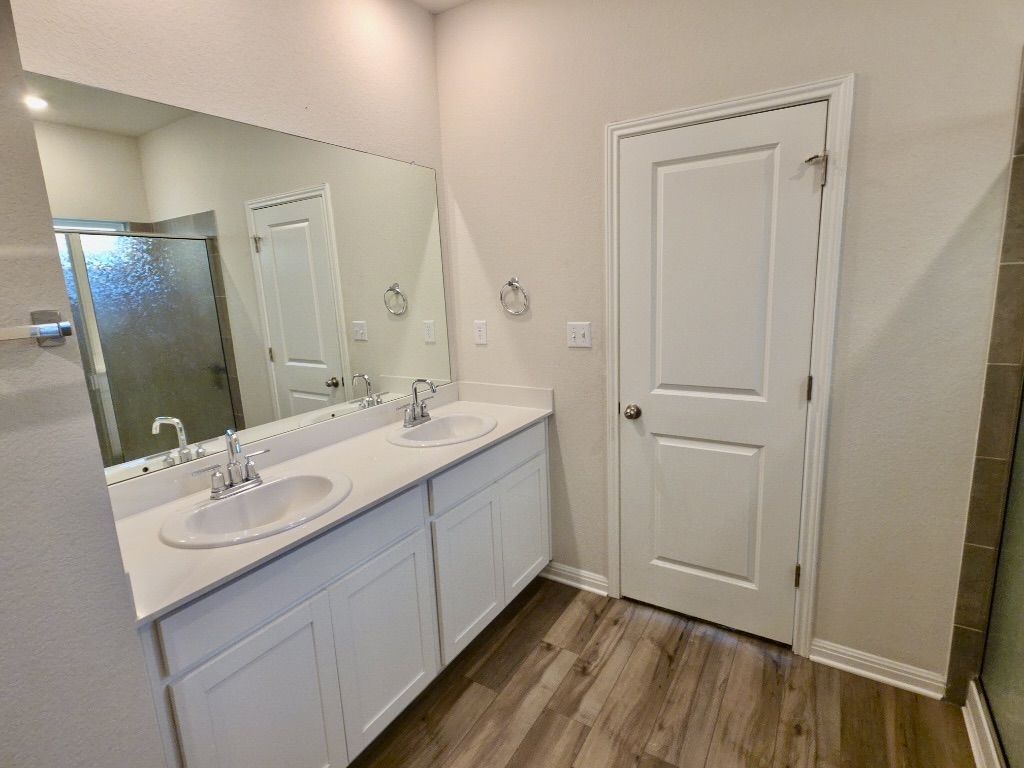 110 Grapefruit Road Hutto, TX 78634 - Photo 12 of 28 Double vanity with dual undermount sinks, chrome fixtures, and a spacious mirror