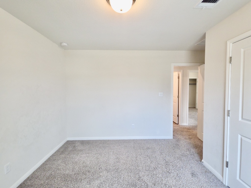 110 Grapefruit Road Hutto, TX 78634 - Photo 18 of 28 Neutral-toned carpeting extends throughout this room, complemented by light-colored wall paint and white baseboards