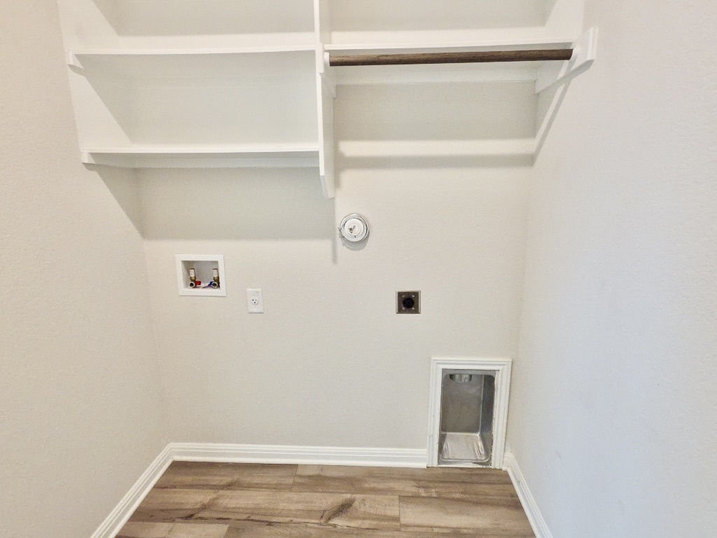 110 Grapefruit Road Hutto, TX 78634 - Photo 27 of 28 Dedicated utility space featuring wood-finish flooring, white baseboards, and light-toned walls