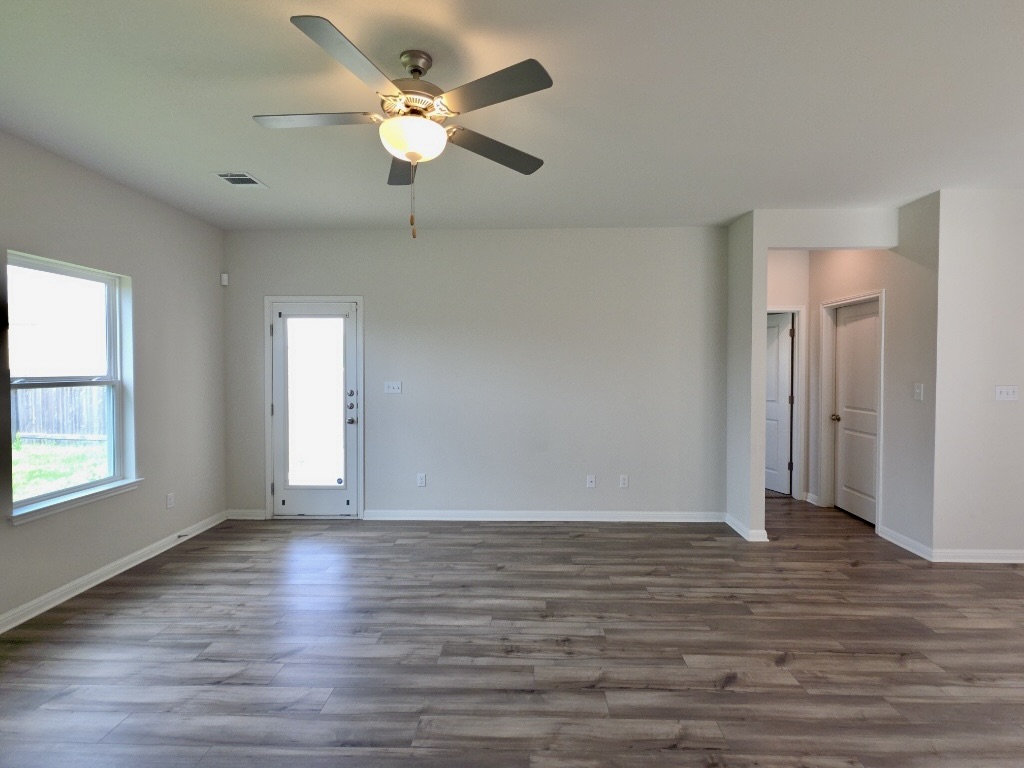 110 Grapefruit Road Hutto, TX 78634 - Photo 3 of 28 Spacious living room featuring wood-finish flooring, light gray wall paint, and white trim