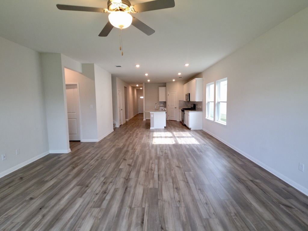 110 Grapefruit Road Hutto, TX 78634 - Photo 4 of 28 Expansive open-concept living area featuring wood-finish flooring, recessed lighting, and a ceiling fan