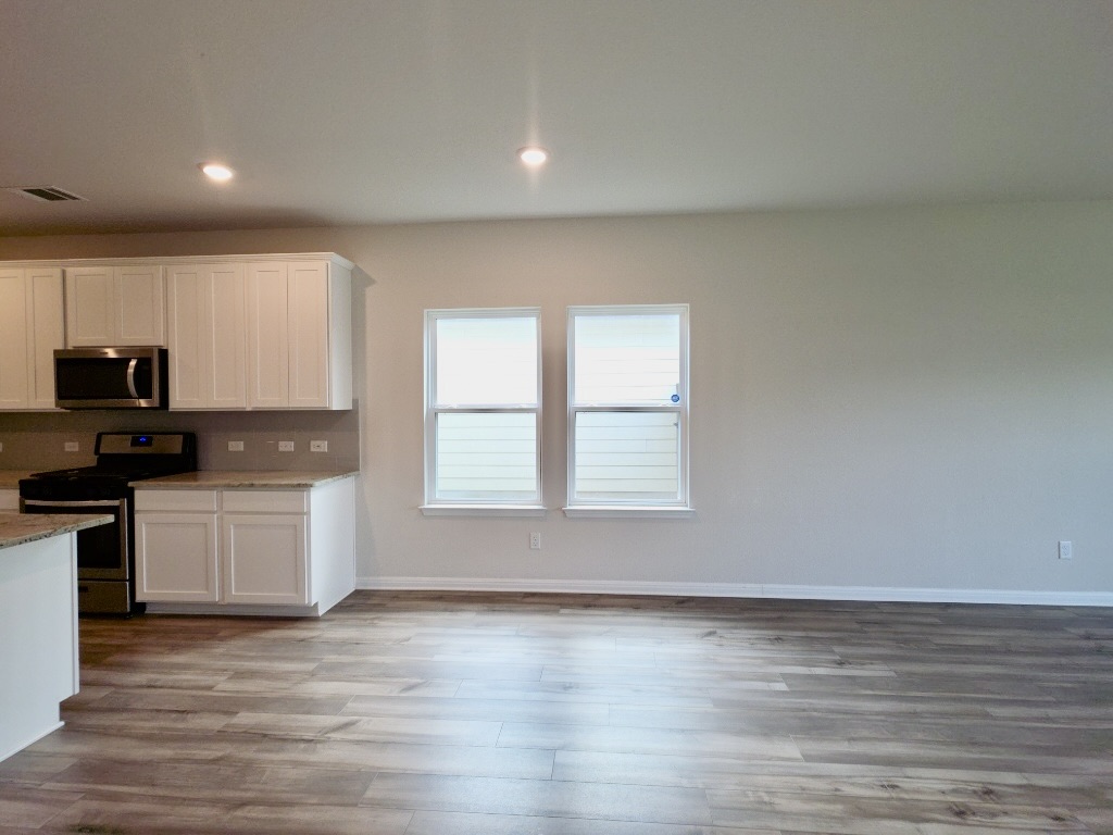 110 Grapefruit Road Hutto, TX 78634 - Photo 8 of 28 Open-concept diningspace featuring wood-finish flooring, recessed lighting, and ample natural light from two windows