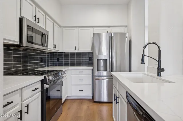 a kitchen with appliances a sink and cabinets