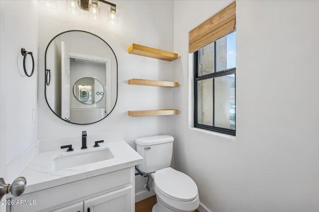 a bathroom with a toilet sink and mirror