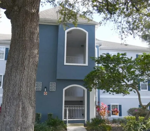 a front view of a house with a tree