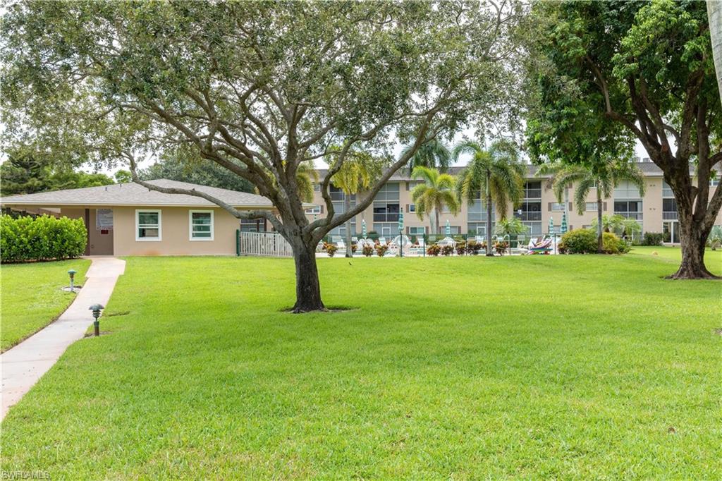 5467 Rattlesnake Hammock Road, Unit 202C Naples, FL 34113 - Photo 12 of 18 a front view of a house with a yard