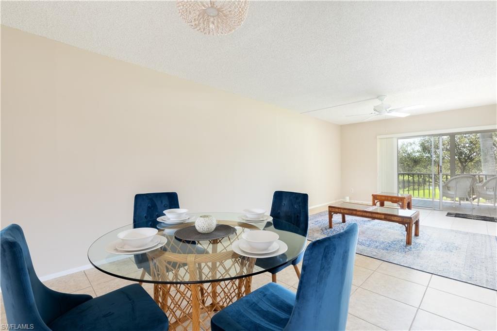 5467 Rattlesnake Hammock Road, Unit 202C Naples, FL 34113 - Photo 3 of 18 a living room with furniture and a table