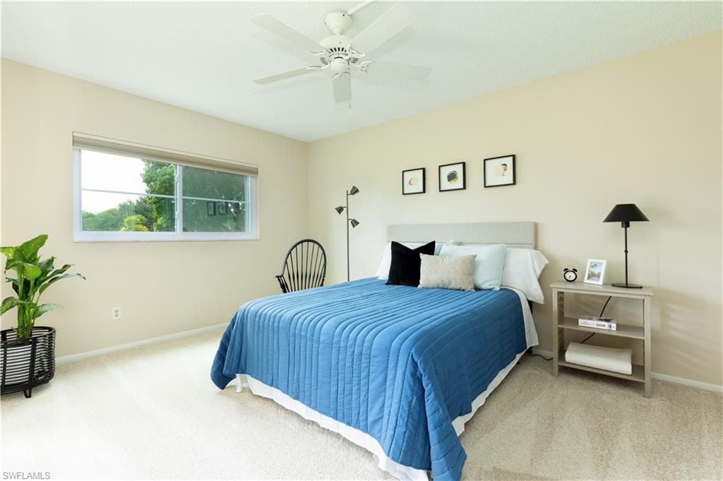 5467 Rattlesnake Hammock Road, Unit 202C Naples, FL 34113 - Photo 5 of 18 a bedroom with a large bed and a potted plant