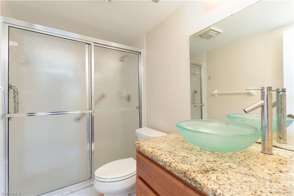 5467 Rattlesnake Hammock Road, Unit 202C Naples, FL 34113 - Photo 6 of 18 a bathroom with a granite countertop sink and a mirror