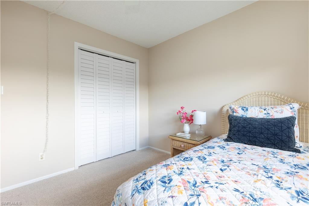 5467 Rattlesnake Hammock Road, Unit 202C Naples, FL 34113 - Photo 8 of 18 a bedroom with a bed and a dresser