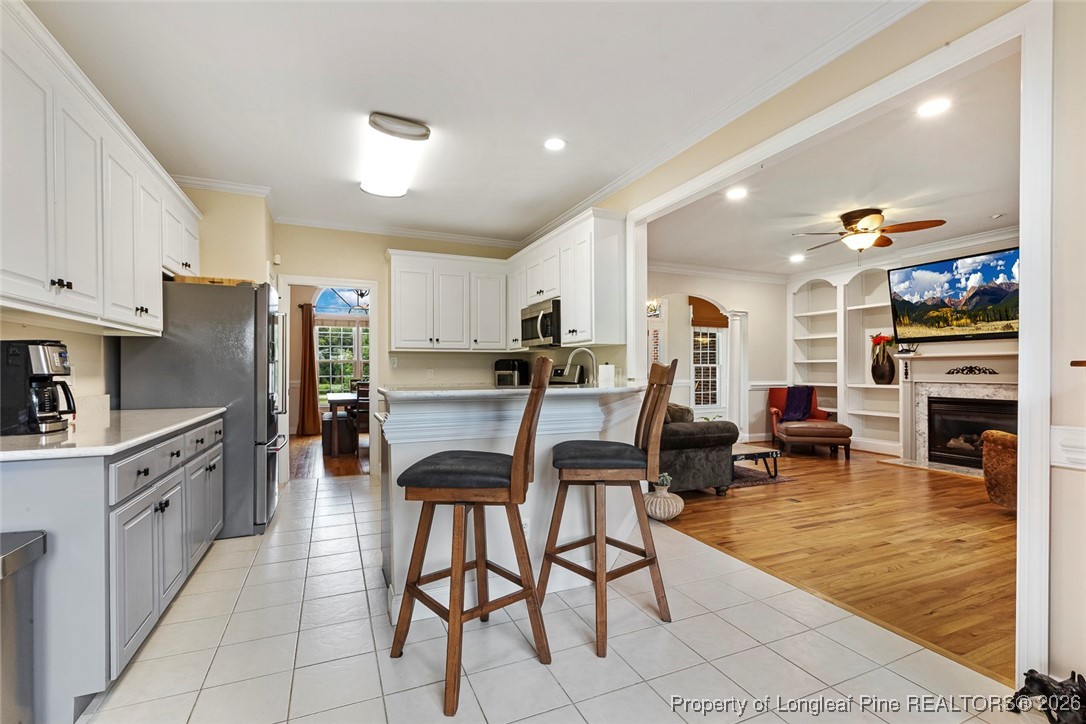 514 Averette Road Rolesville, NC 27571 - Photo 11 of 38 a kitchen with stainless steel appliances granite countertop a stove top oven a sink a dining table and chairs with wooden floor