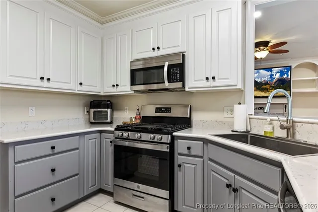 a kitchen with granite countertop white cabinets and stainless steel appliances