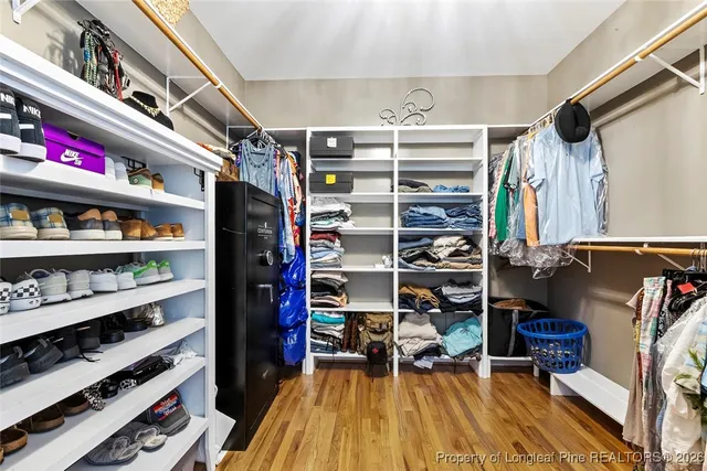 a view of walk in closet with clothes and shoes