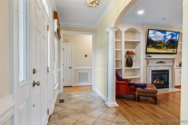 a living room with furniture a flat screen tv and a fireplace