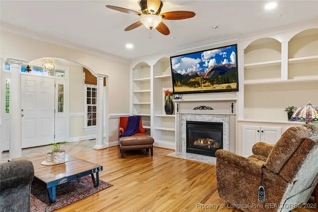 a living room with furniture a flat screen tv and a fireplace