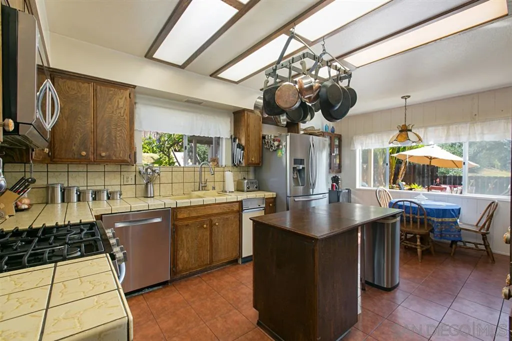 3729 Sinclair Lane Spring Valley, CA 91977 - Photo 9 of 24 a kitchen with stainless steel appliances a sink a counter top space cabinets and wooden floor