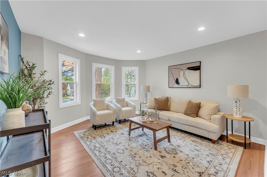 18155 Libby Road Maple Heights, OH 44137 - Photo 7 of 32 Living area featuring light wood-finish flooring, recessed lighting, a bay window with three large windows, and a decorative area rug