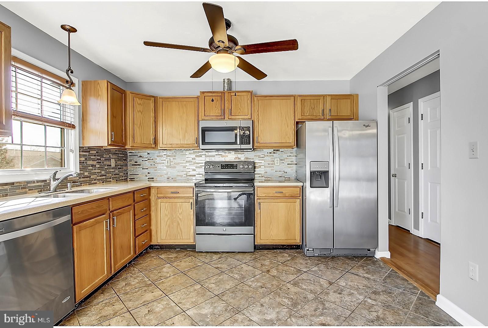 1663 Taylor Drive Hanover, PA 17331 - Photo 13 of 29 a kitchen with granite countertop a refrigerator a sink and white cabinets