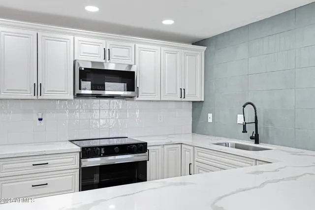 a view of kitchen with stainless steel appliances kitchen island sink refrigerator and microwave