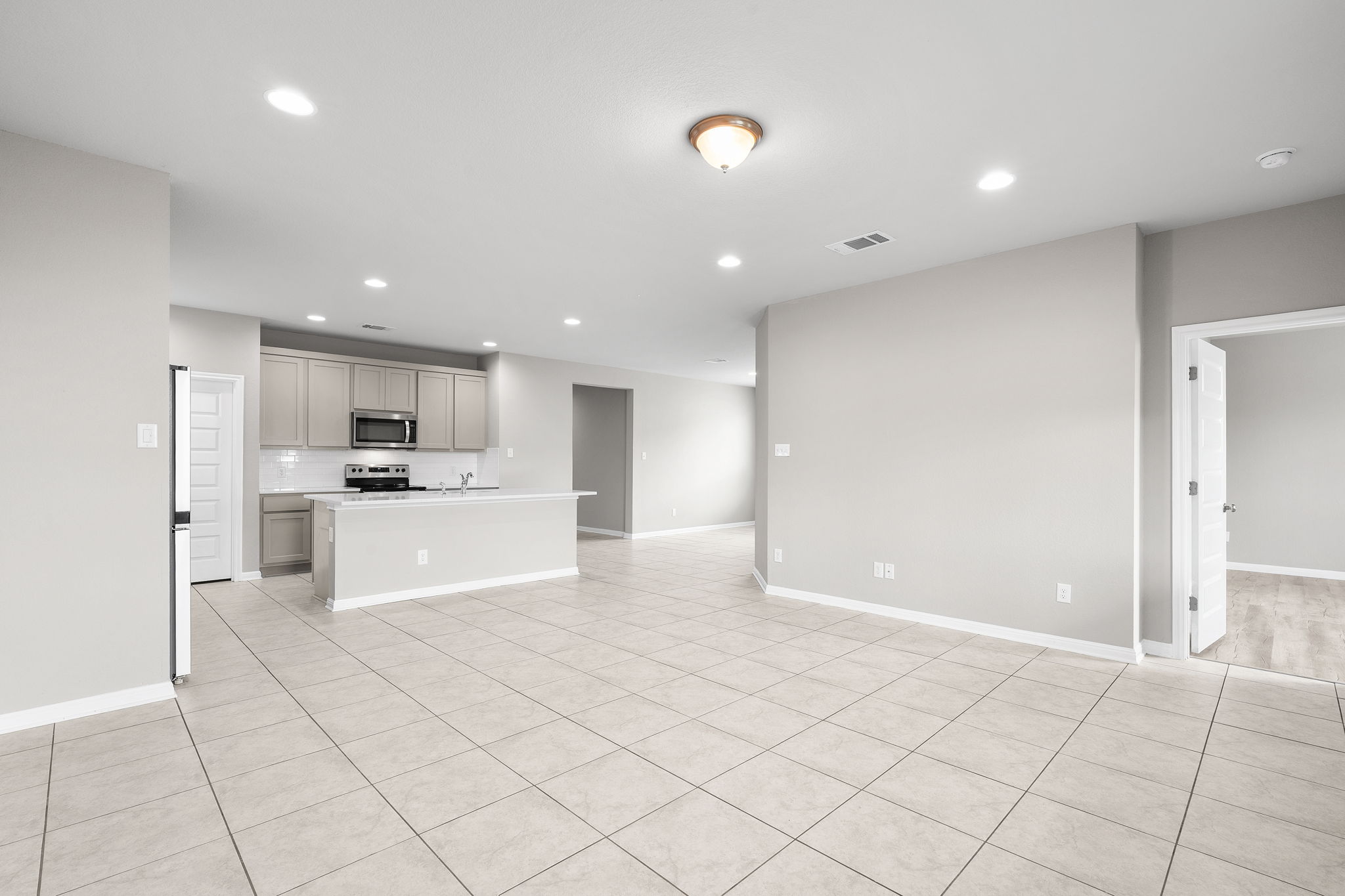 313 Mclintock Road Jarrell, TX 76537 - Photo 22 of 40 An open-concept living space integrates a well-appointed kitchen with an expansive tiled area perfect for entertaining.