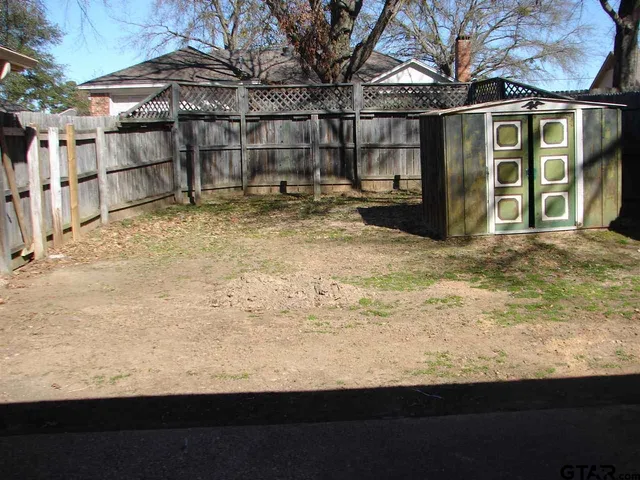 a view of a blue house with wooden fence