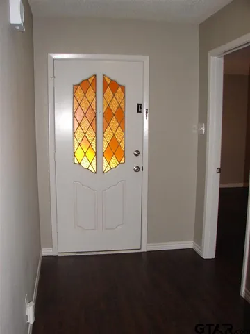an empty room with wooden floor a glass door and a window