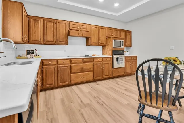 a kitchen with stainless steel appliances granite countertop a kitchen island hardwood floor sink and stove