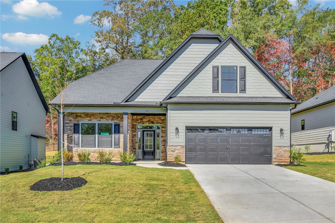 Modern home featuring mixed material facade and a spacious driveway.