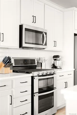 a kitchen with granite countertop cabinets stainless steel appliances and wooden floor