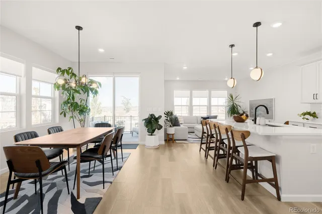 a view of a dining room and livingroom with furniture wooden floor a chandelier