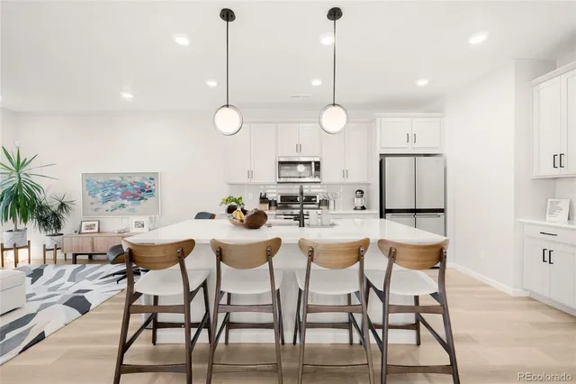 a view of a dining room and livingroom with furniture wooden floor a rug a rug a fireplace and a chandelier