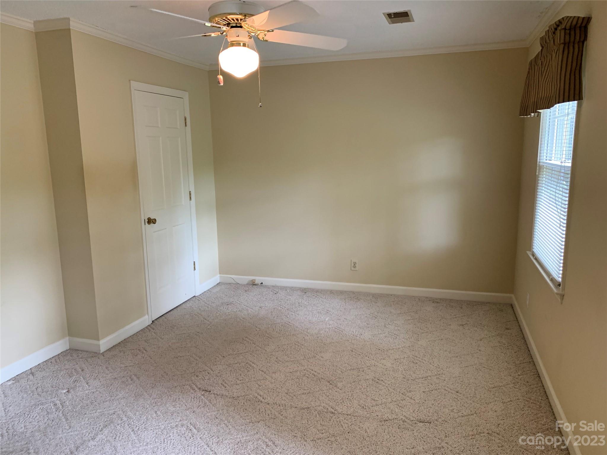 909 Nightingale Road Rock Hill, SC 29732 - Photo 13 of 38 an empty room with a chandelier fan and windows