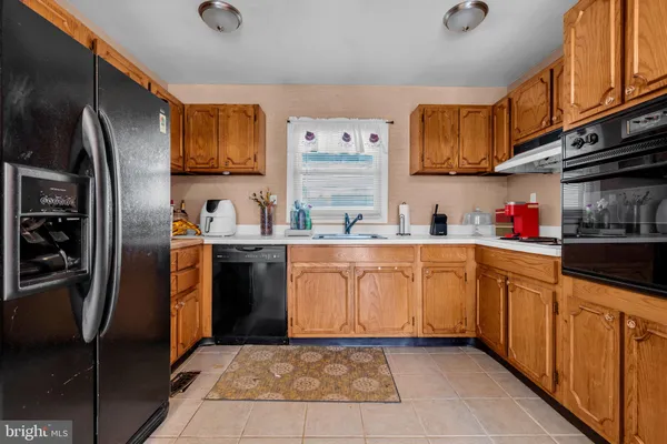 a kitchen with stainless steel appliances granite countertop a refrigerator oven a sink and dishwasher