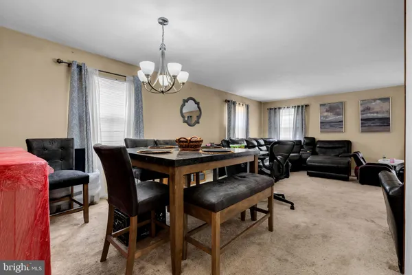 a view of a dining room with furniture and a chandelier